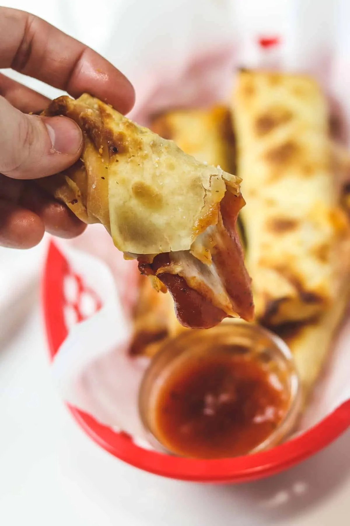 dipping an air fryer pizza roll in sauce