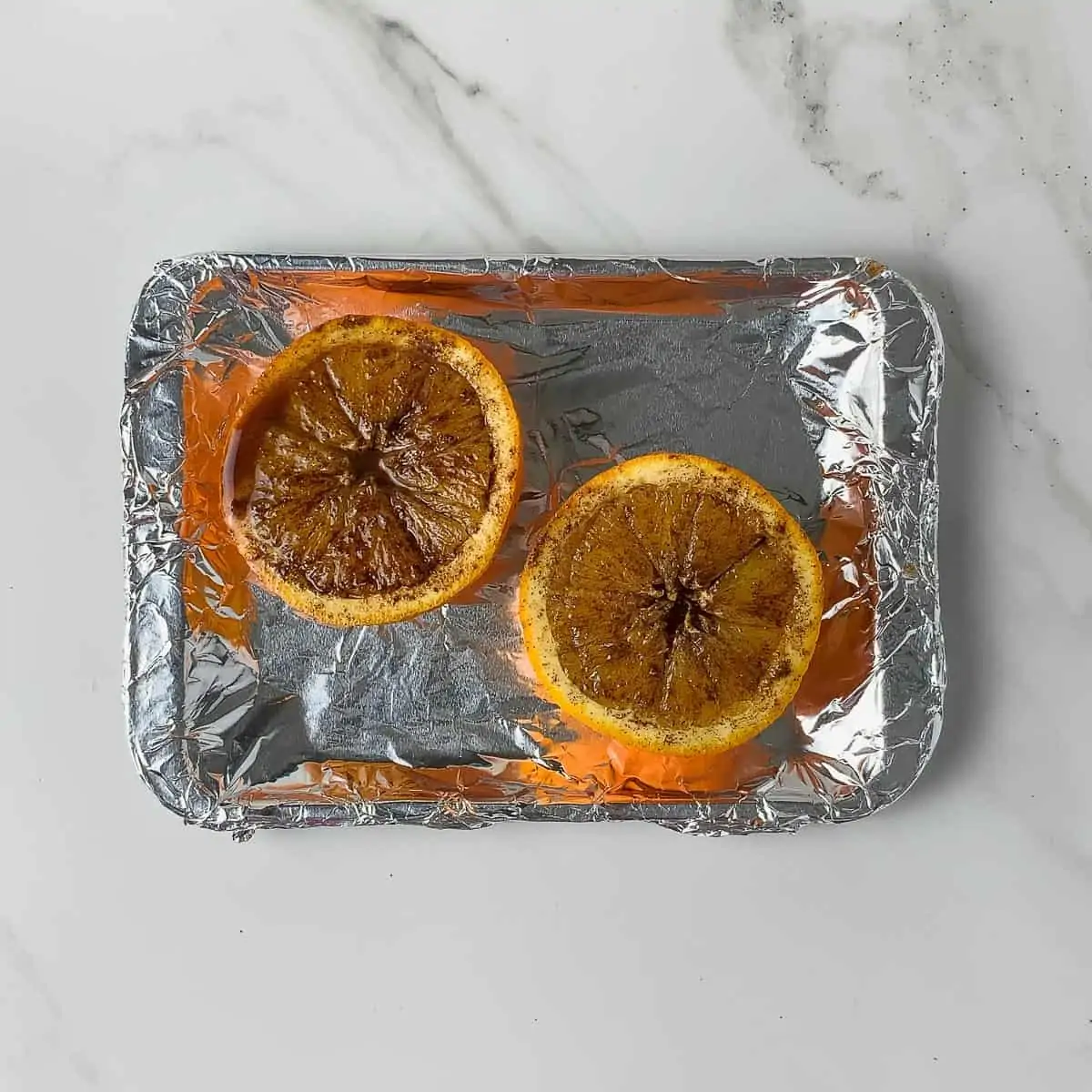 uncooked orange halves on baking sheet
