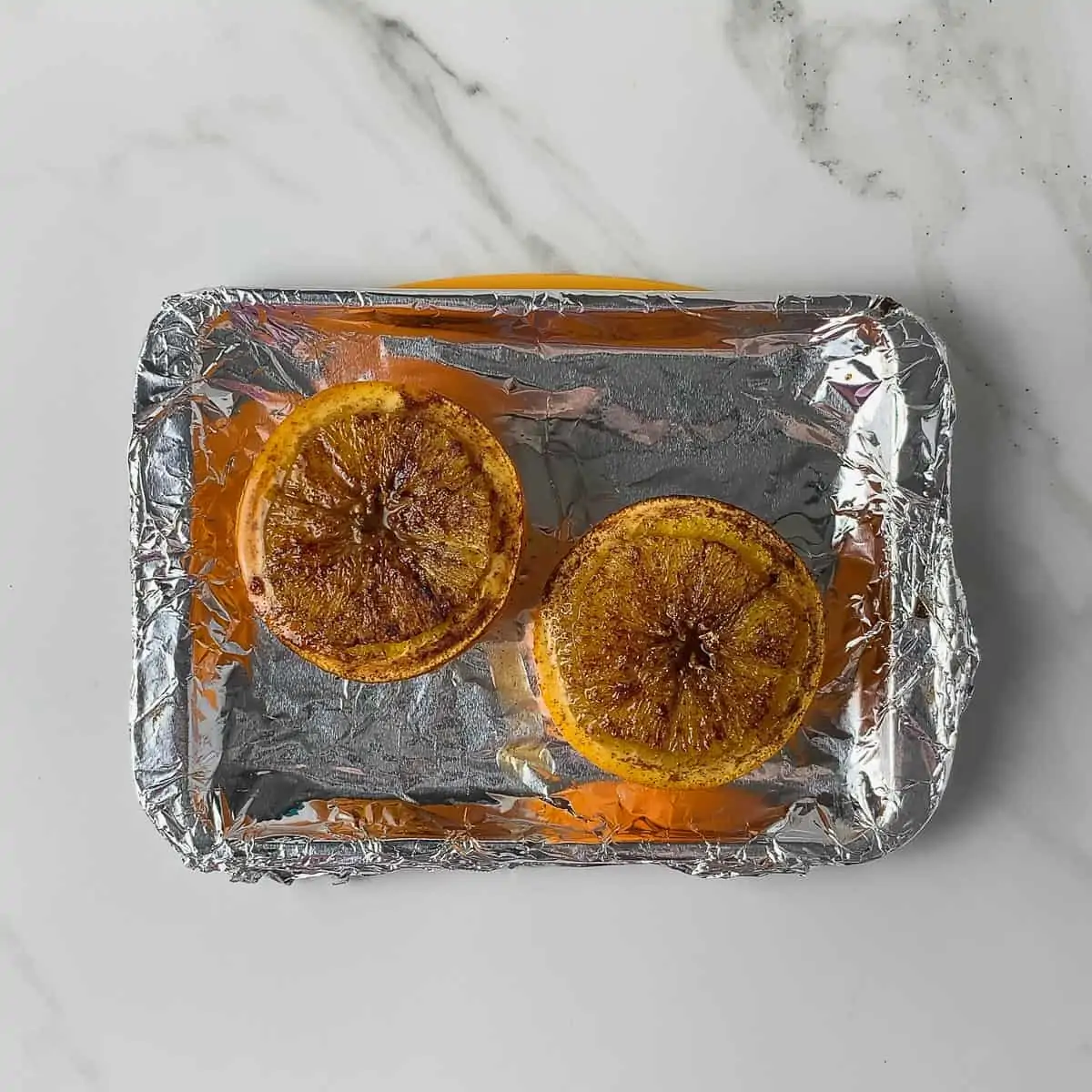 cooked baked oranges on baking sheet