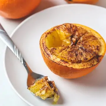 baked orange with a wedge cut into a spoon