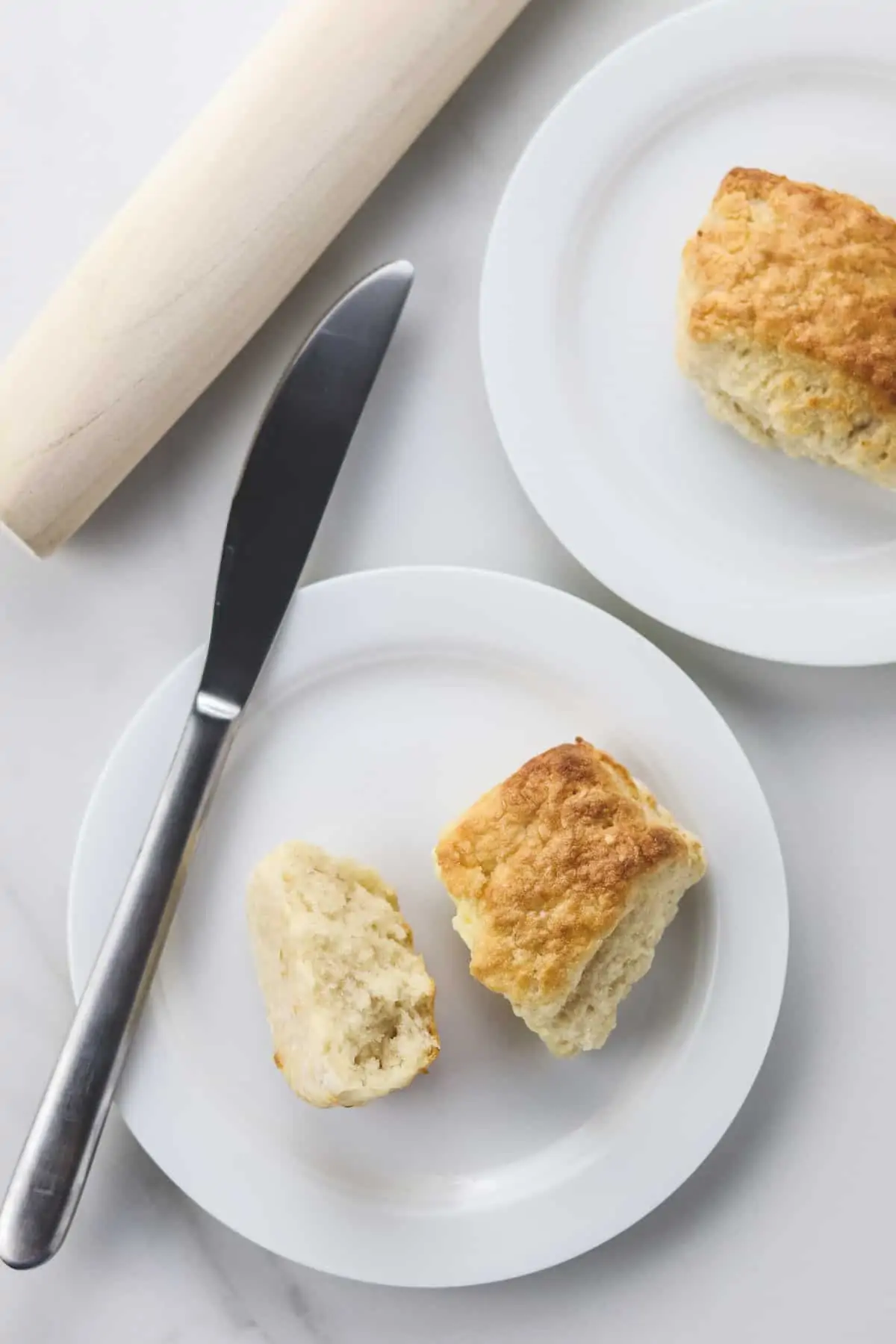 healthy air fryer biscuits on white plates with a butter knife