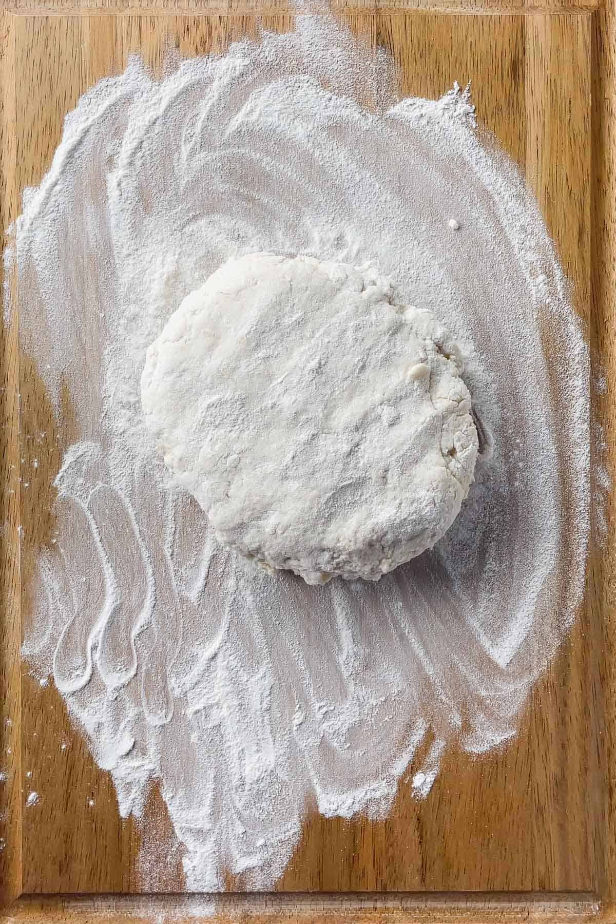 ball of biscuit dough on a floured surface