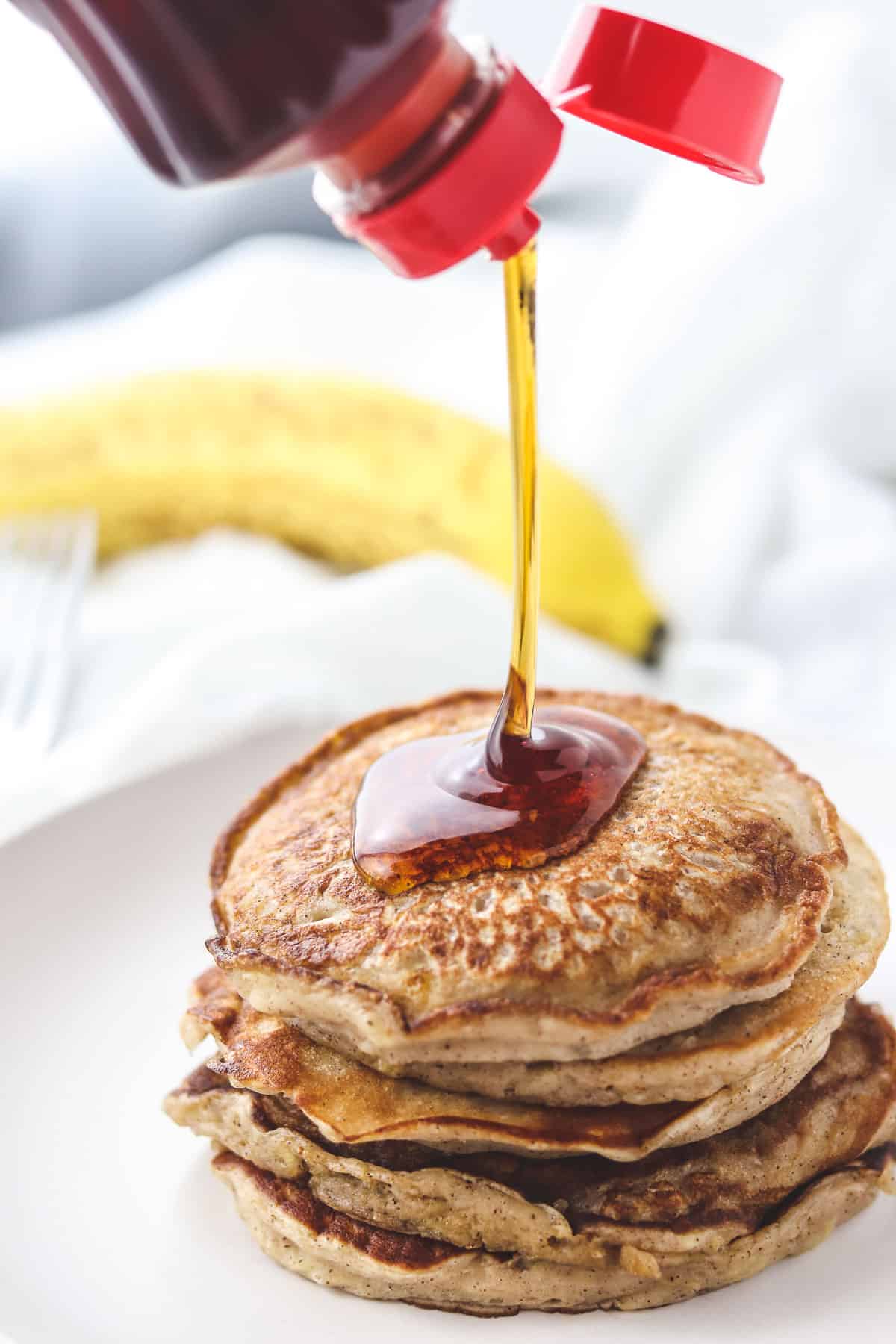 pouring syrup on a stack of low calorie pancakes