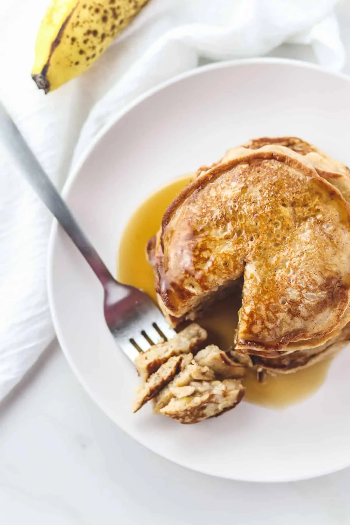 a plate of healthy pancakes with a bite taken out