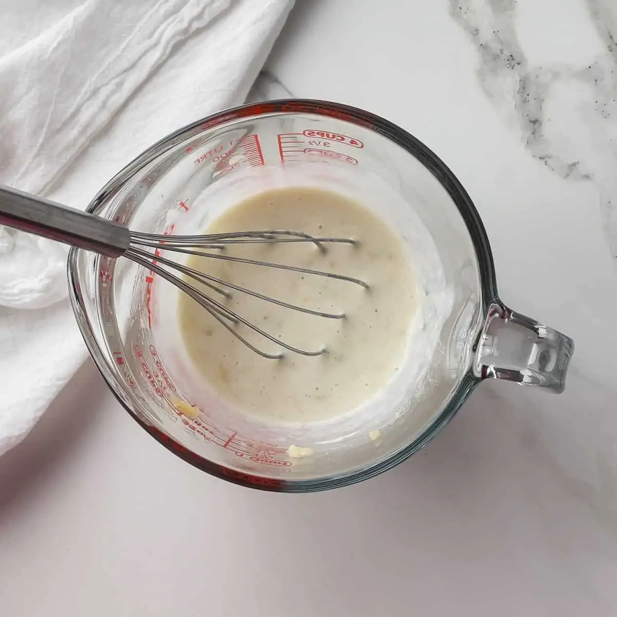 wet ingredients for pancakes mixed in measuring cup