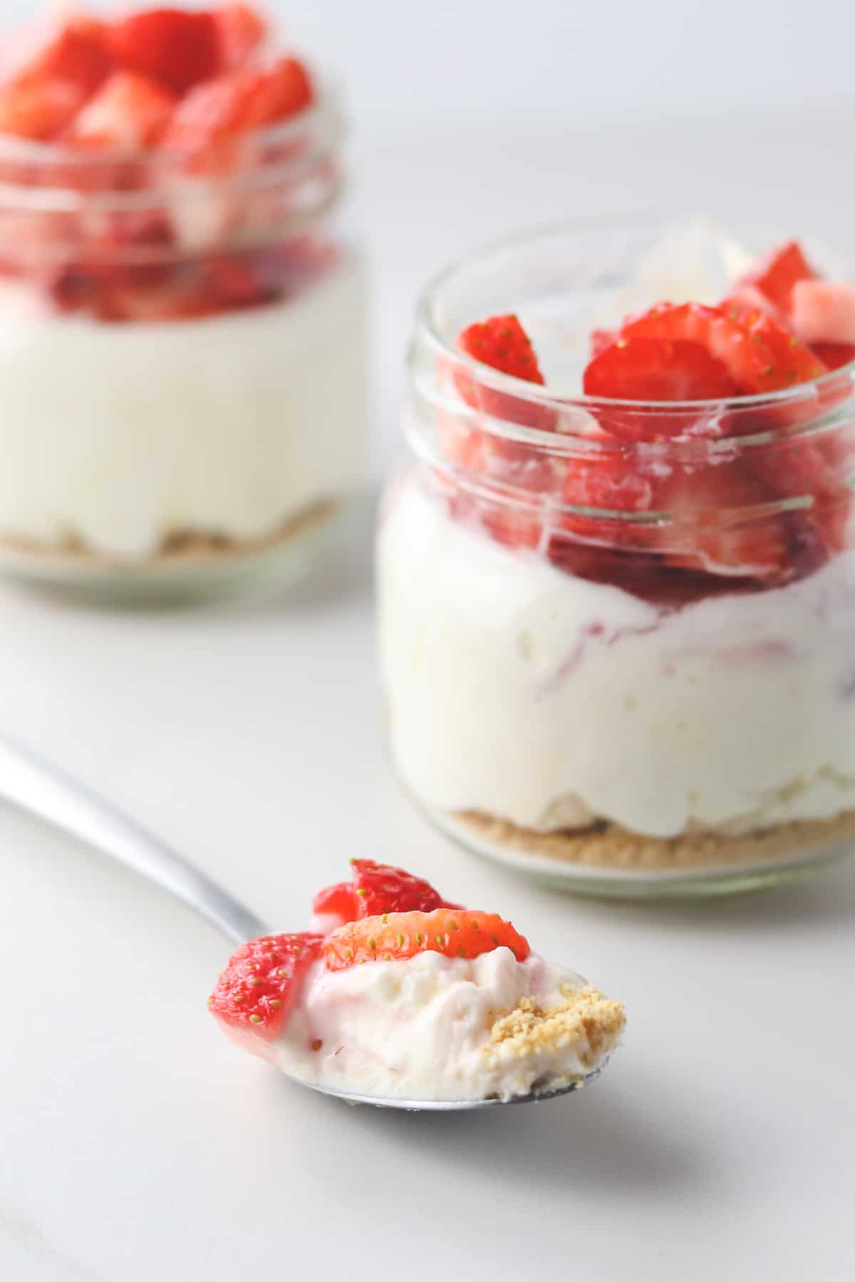 two jars of low calorie cheesecake with a spoonful