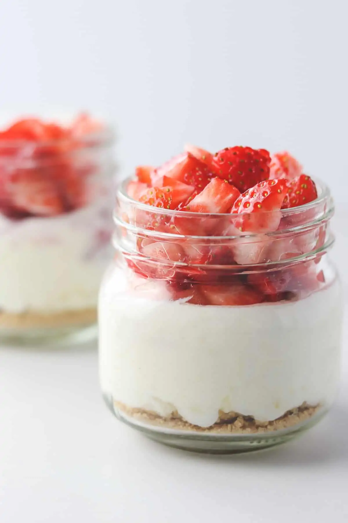 jars of low calorie cheesecake topped with strawberries