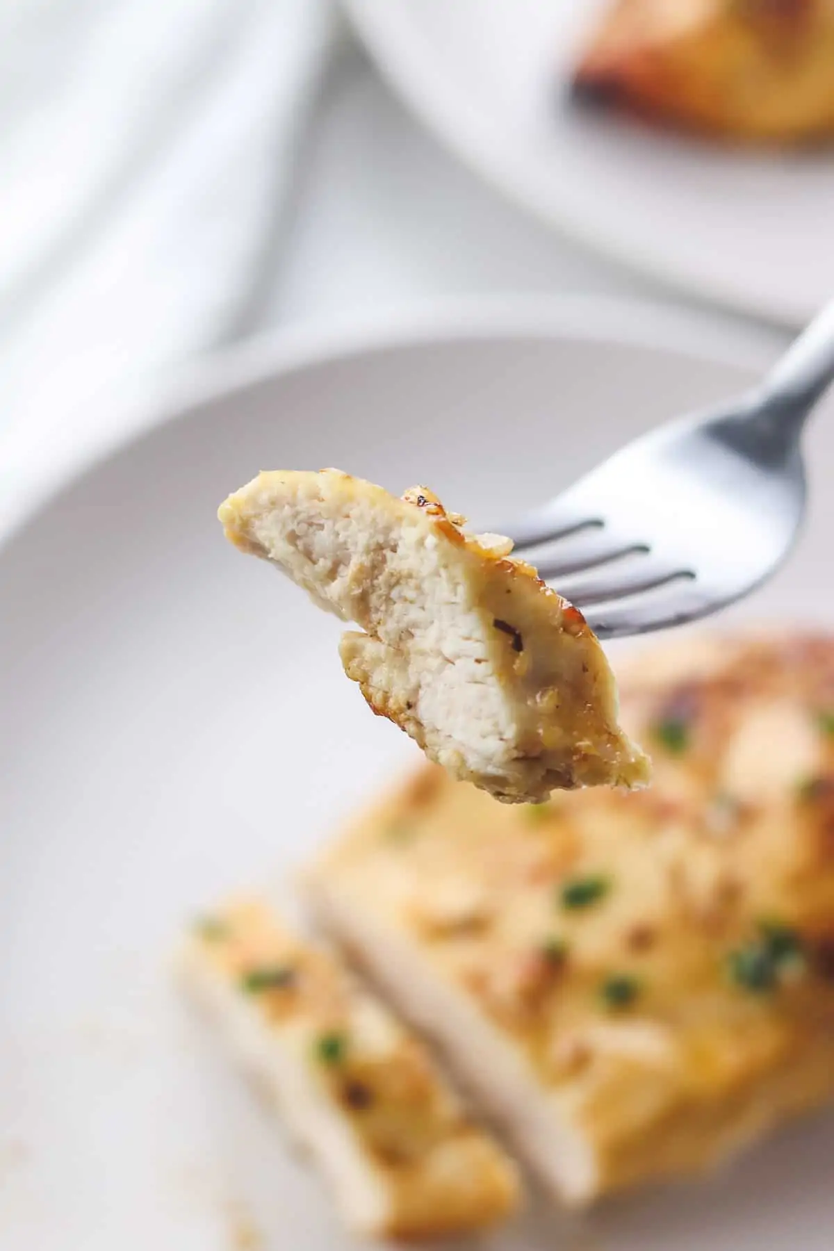 taking a bite of chicken breast with a fork