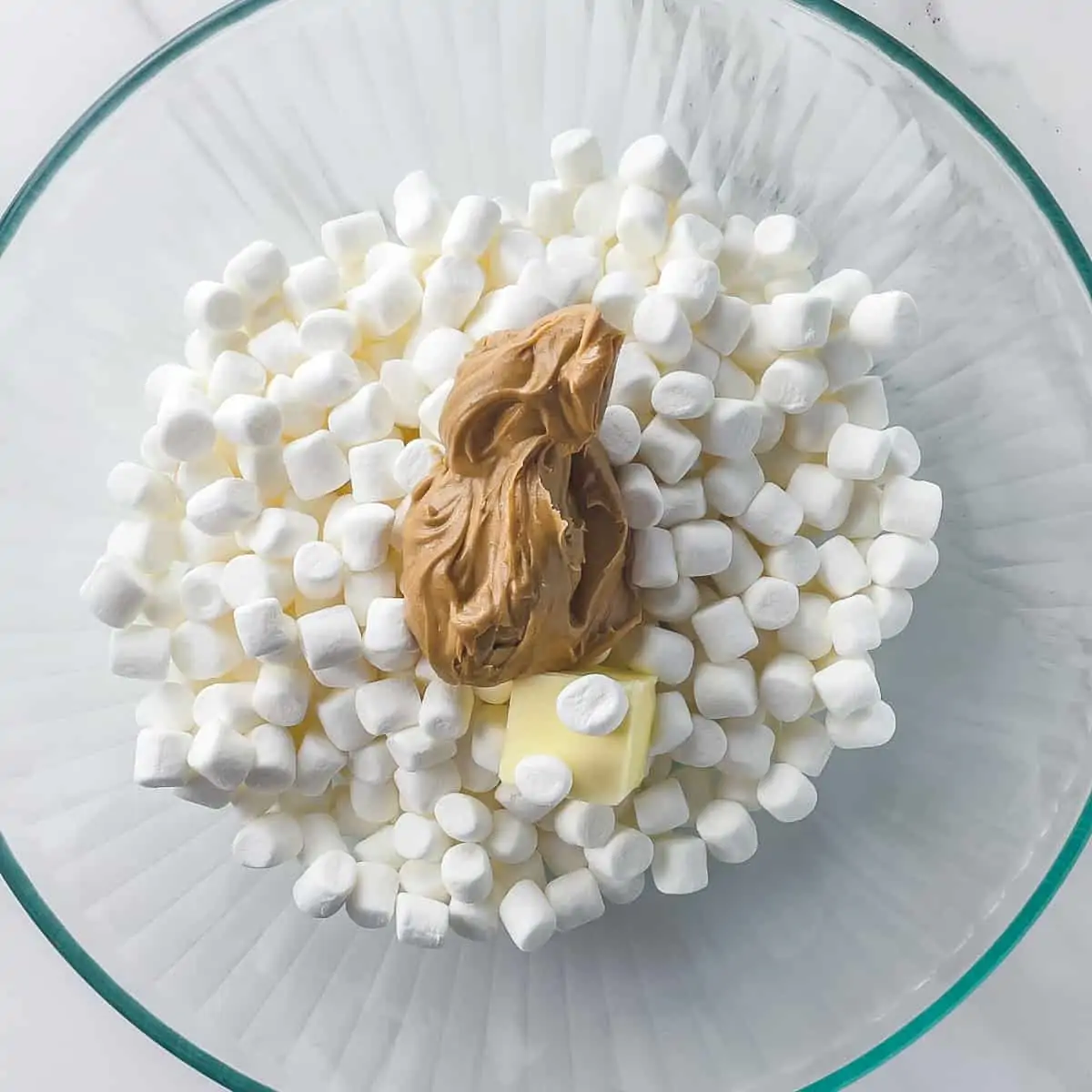 marshmallows, peanut butter, and butter in a glass mixing bowl