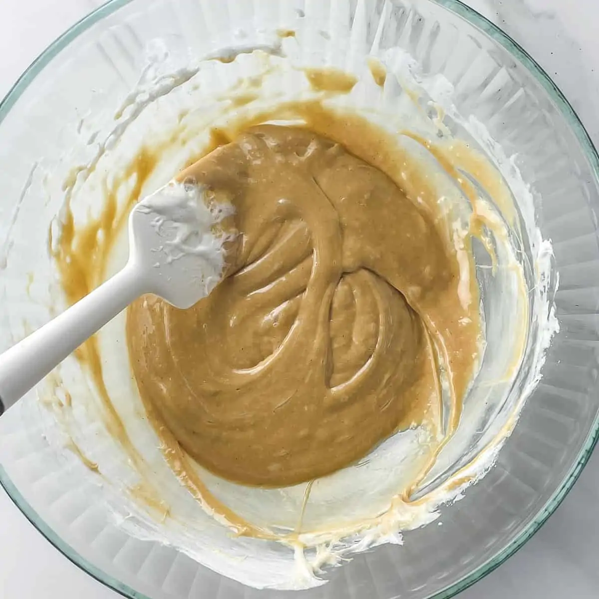 melted marshmallows, peanut butter, and butter in a glass mixing bowl