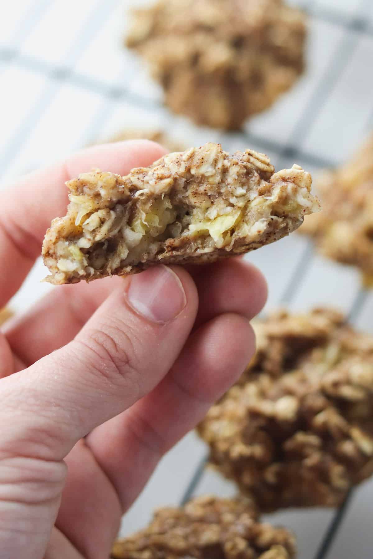 holding a banana oatmeal cookie with a bite taken out of it