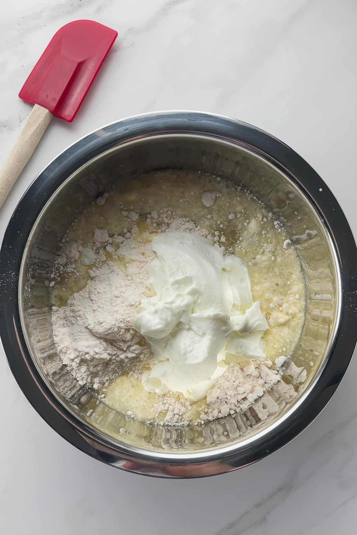 cake mix, water, and yogurt in a mixing bowl before stirring