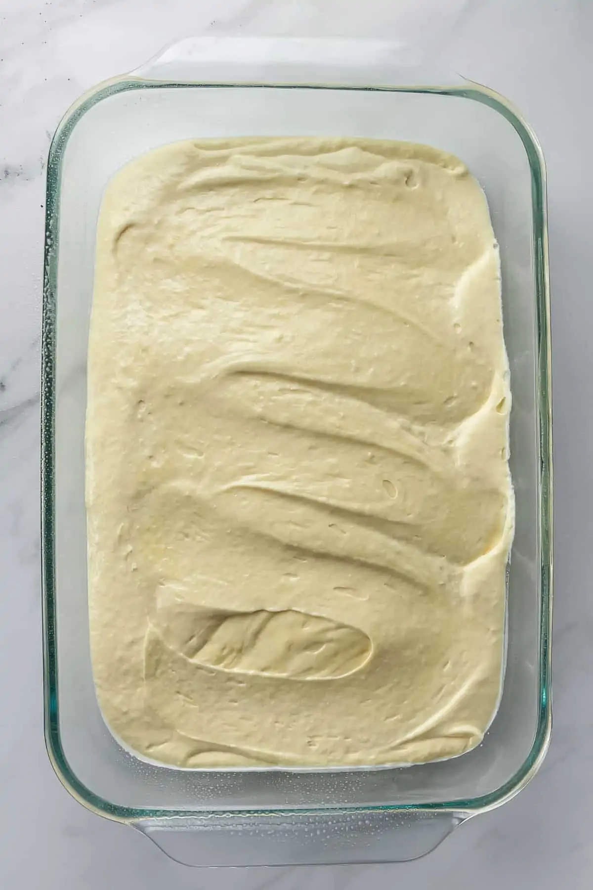 unbaked cake batter in a glass pan