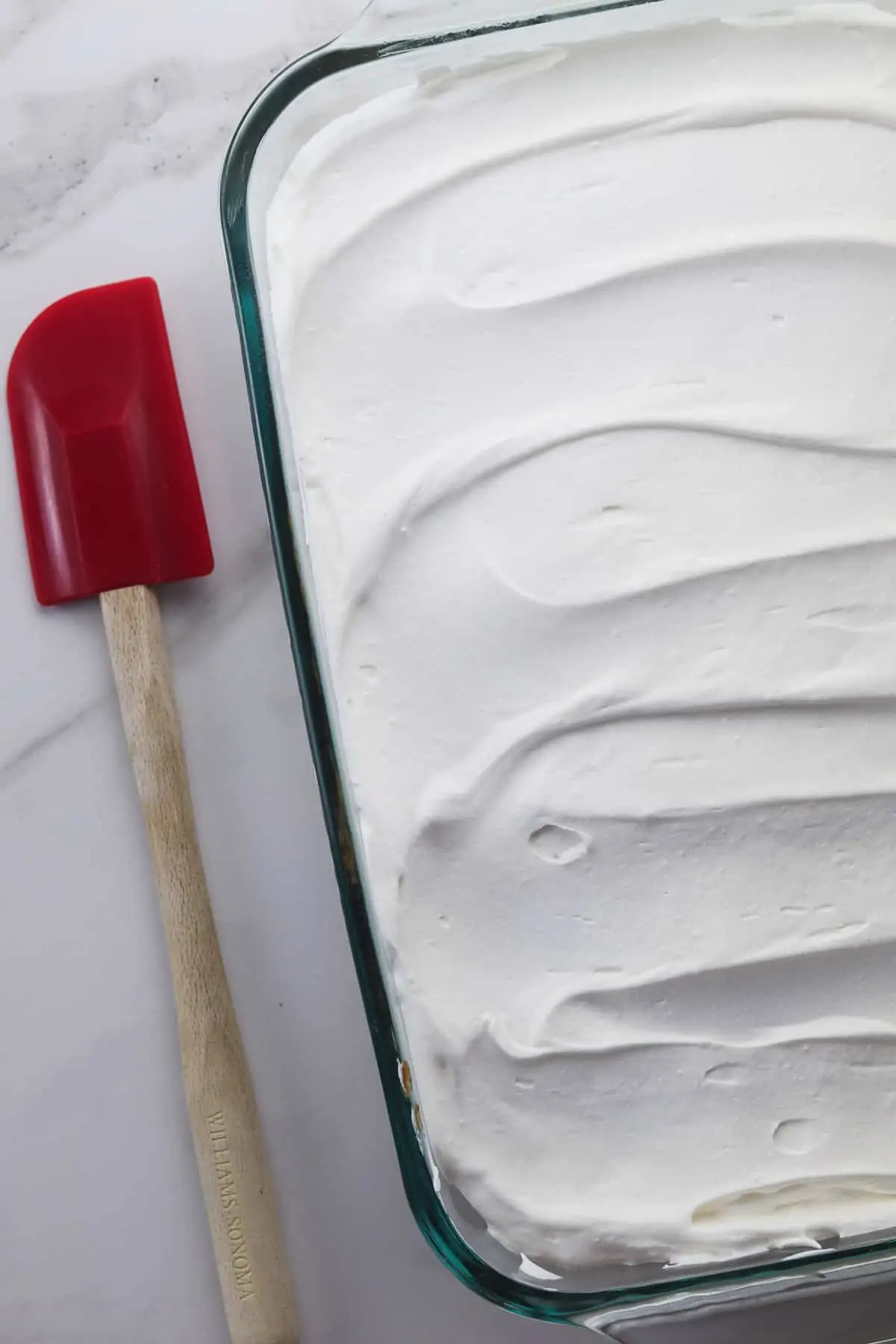 finished cake topped with cool whip frosting