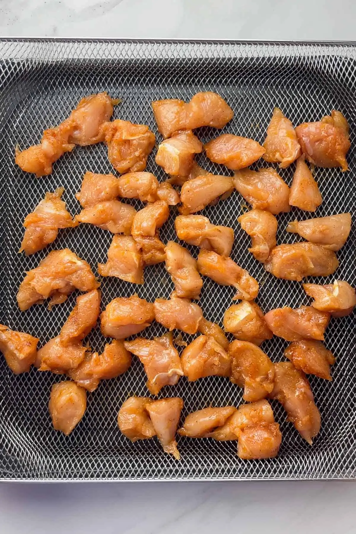 uncooked rotisserie chicken bites in air fryer basket