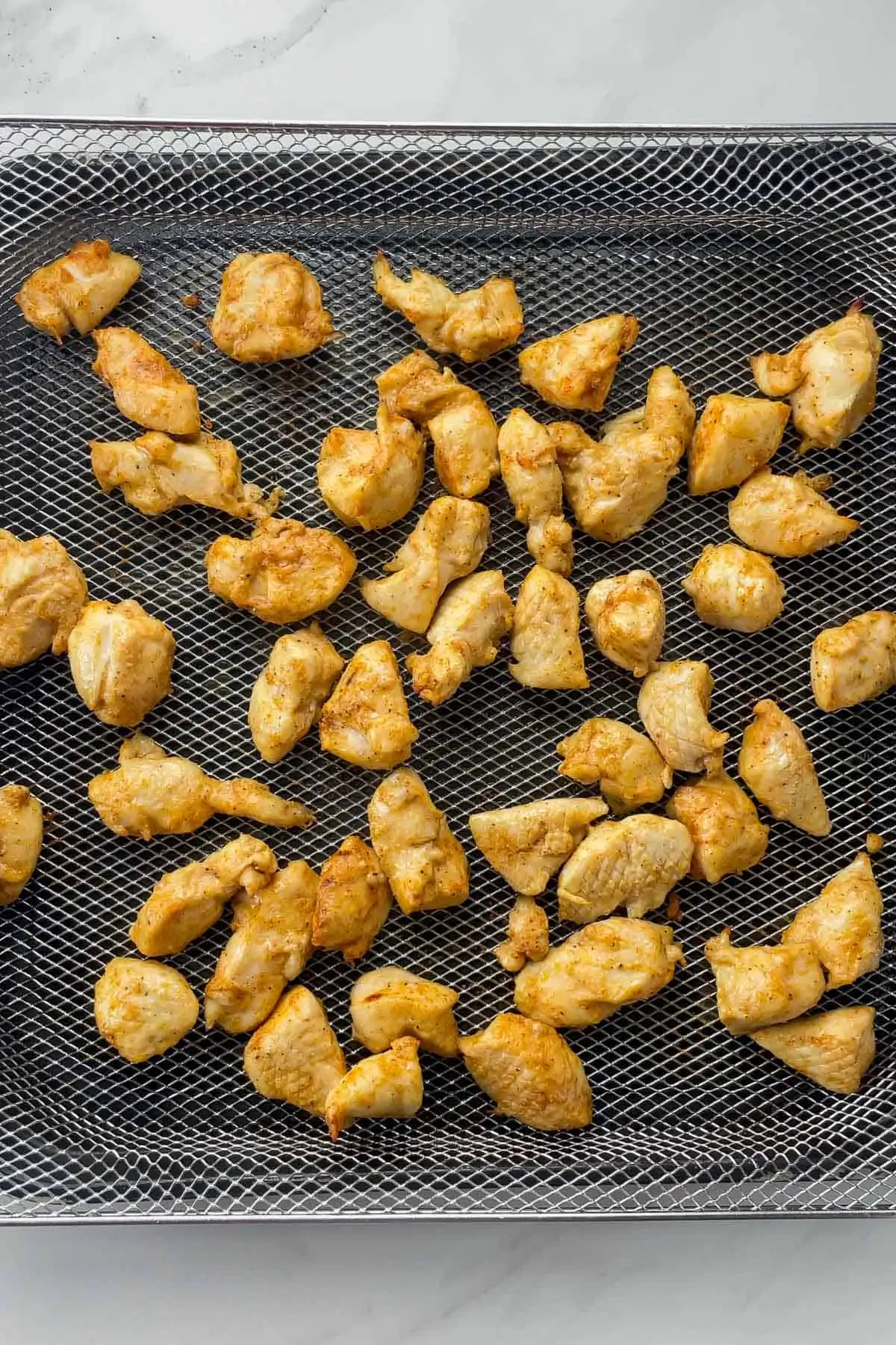 cooked rotisserie chicken bites in air fryer basket