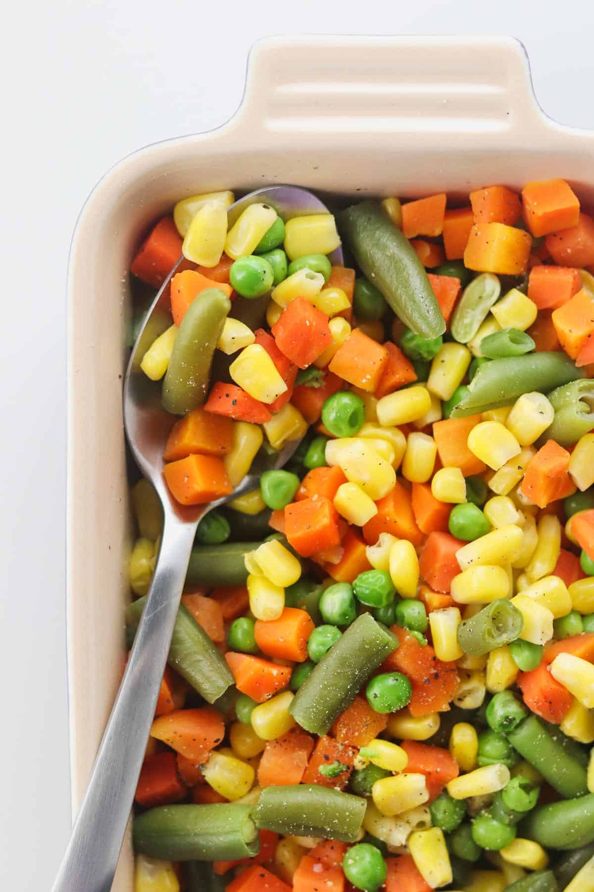 mixed vegetables in a serving dish with a spoon
